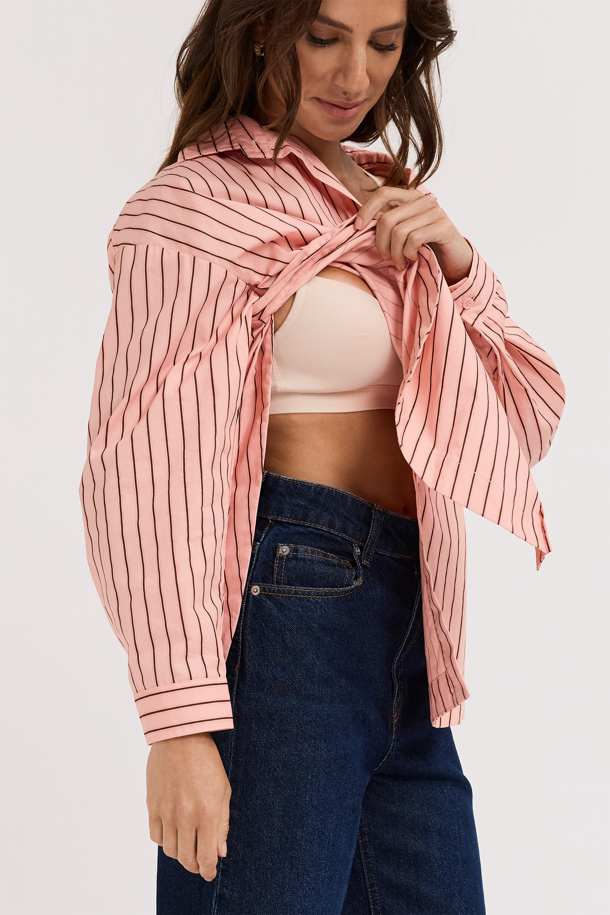 A woman showing the easy access breastfeeding style of a button up shirt