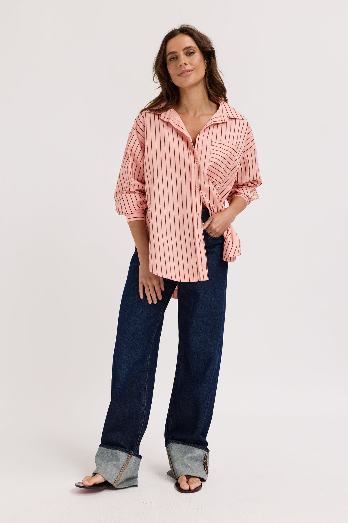 Woman wearing prange breastfeeding buttonup shirt with stripes and dark jeans