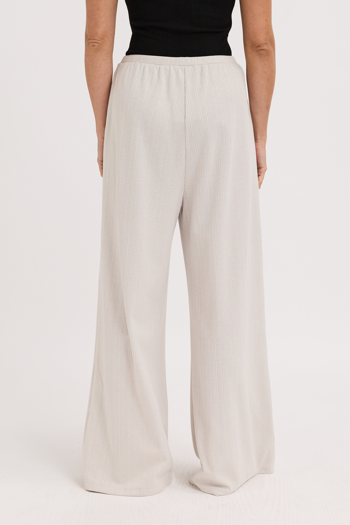 Beige wide-leg pants worn by a person on a white background