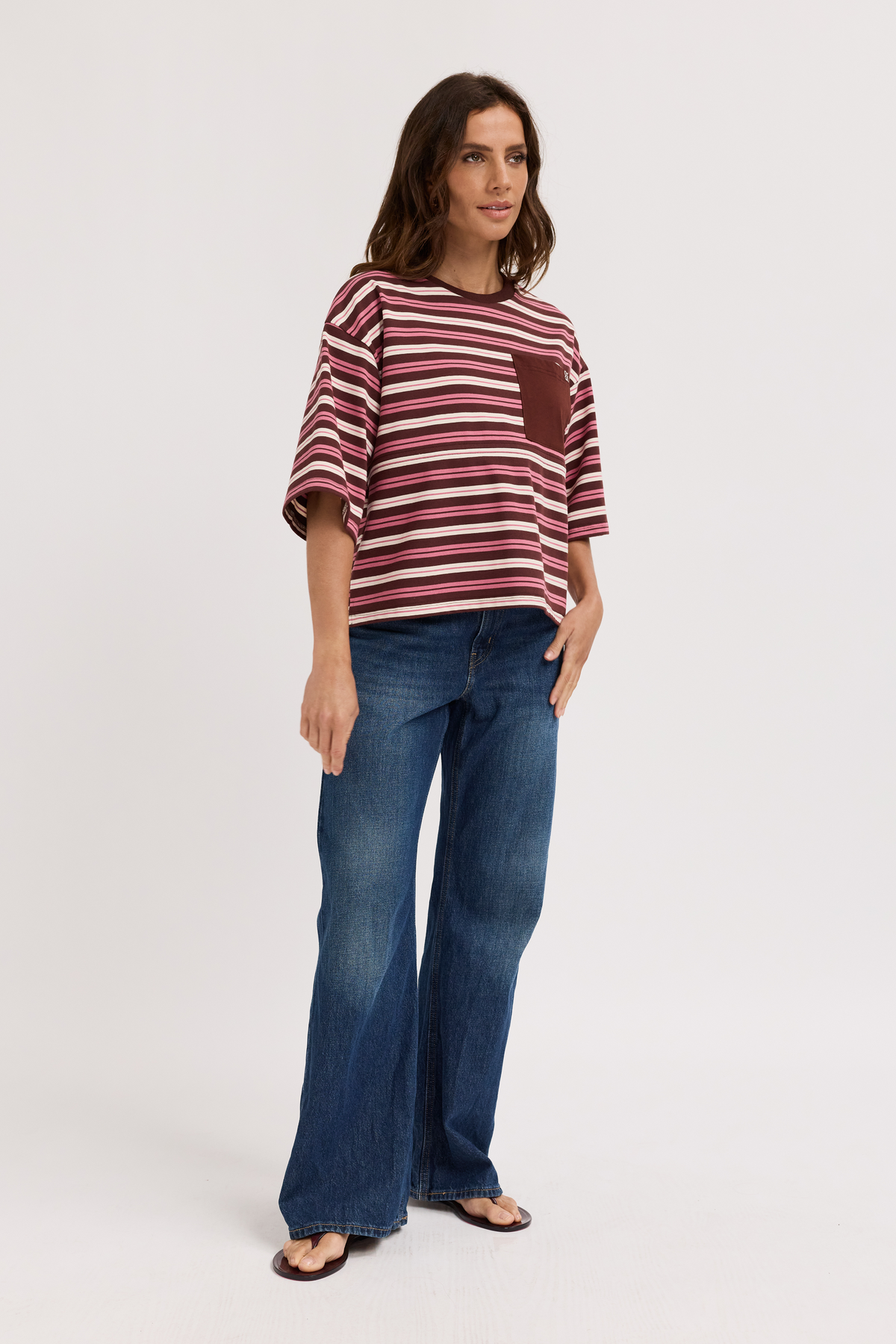 Woman wearing a striped shirt and jeans on a white background